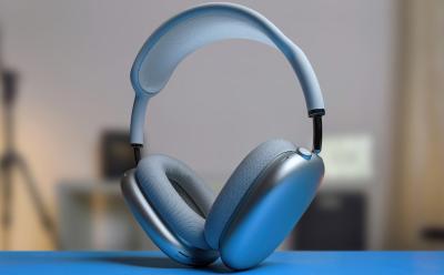 shot of the Apple AirPods Max placed on a blue flat surface with a blurred background