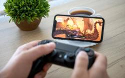 person holding a controller while playing a game on an iPhone