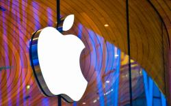 shot of the Apple Logo on top of a glass wall in front of an Apple Store