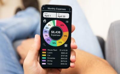shot of hand holding a phone with a screen showing a monthly expense tracker