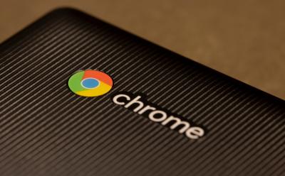 Chrome logo on a black textured Chromebook