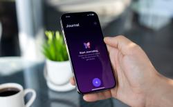 shot of a hand holding an iPhone showing the Journal app home screen