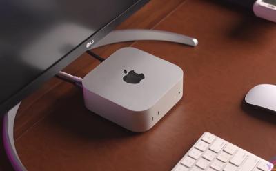 mac mini m4 sitting under the monitor on a table