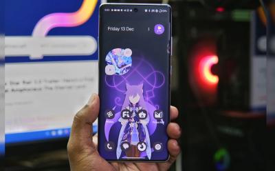 hand holding OnePlus 12R running OxygenOS 15 with a purple color lockscreen