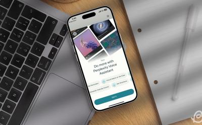show of an iPhone placed on top of a MacBook with the Perplexity app's AI voice assistant on the screen