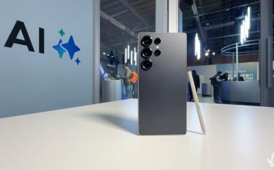 Samsung Galaxy S25 Ultra placed upright on a desk with part of Galaxy AI visible in the background