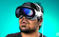 person wearing Apple Vision Pro in front of a teal background